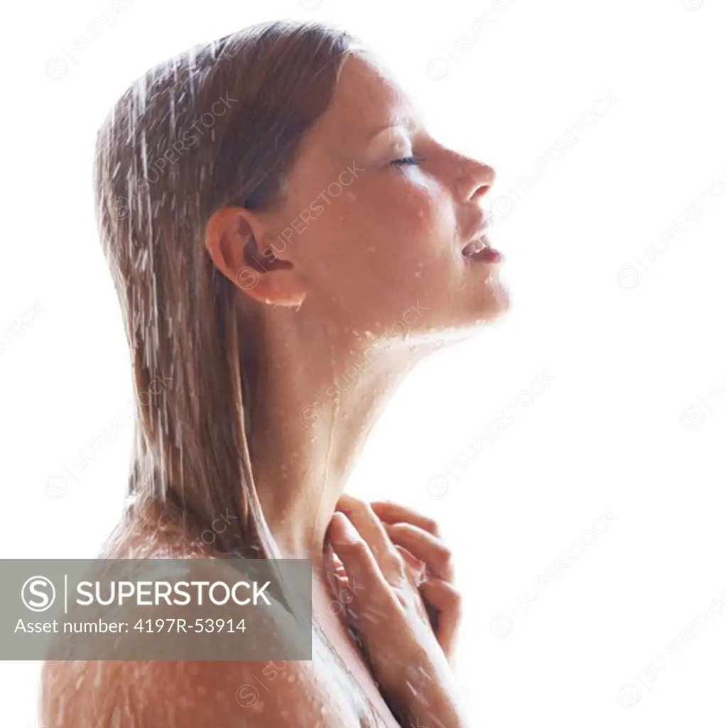 Pretty young girl standing under a stream of water in a light shower