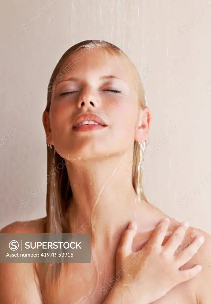 Relaxed young woman enjoing bath under water shower