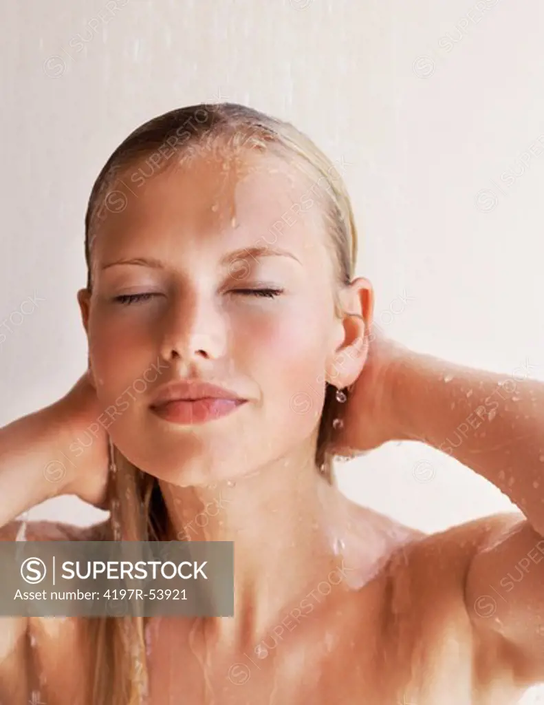 Closeup of young woman under shower in bath room