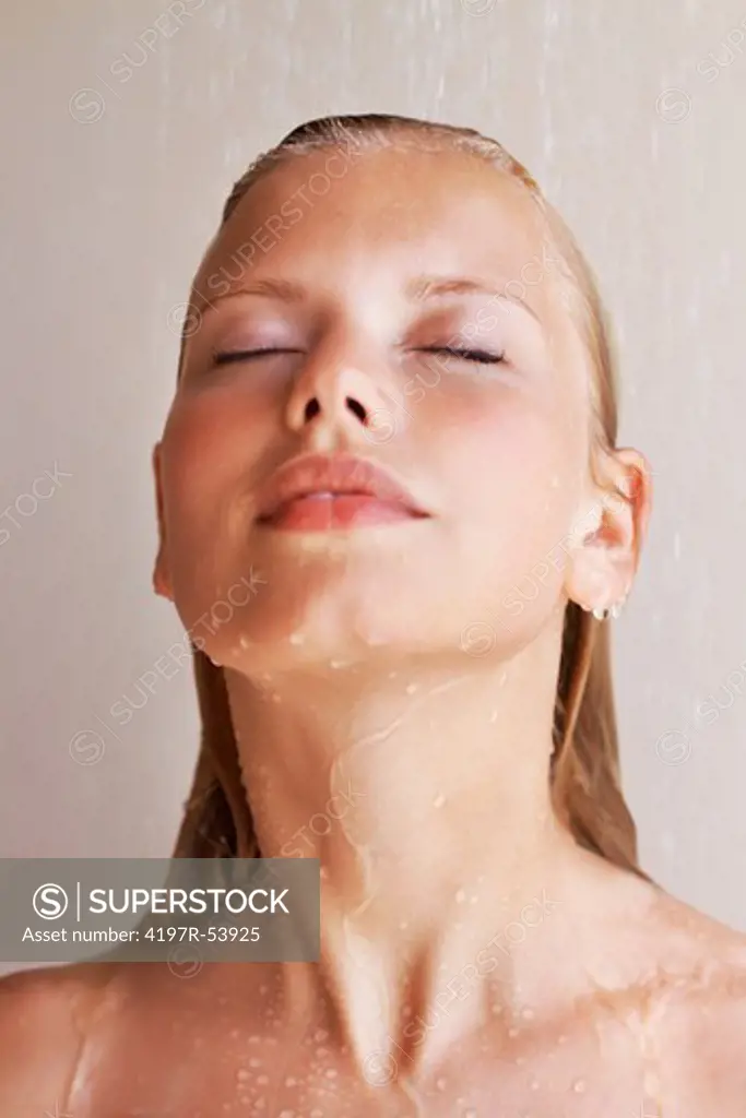Attractive young woman under shower taking a relaxing bath