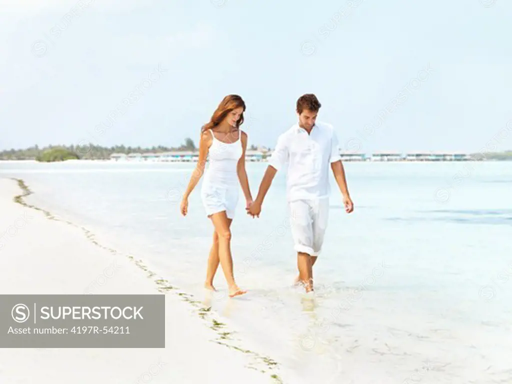 Happy young couple walking along the seashore