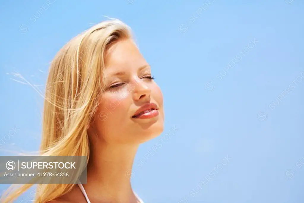 Closeup of woman relaxing on the beach with eyes closed
