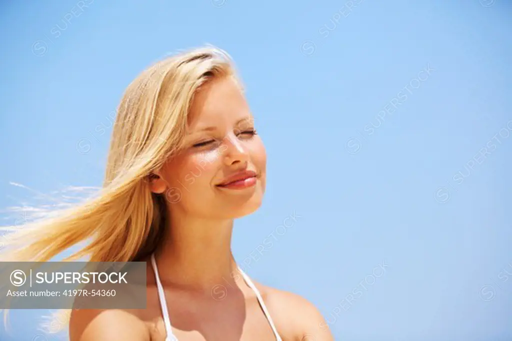 Closeup of carefree young woman smiling with eyes closed