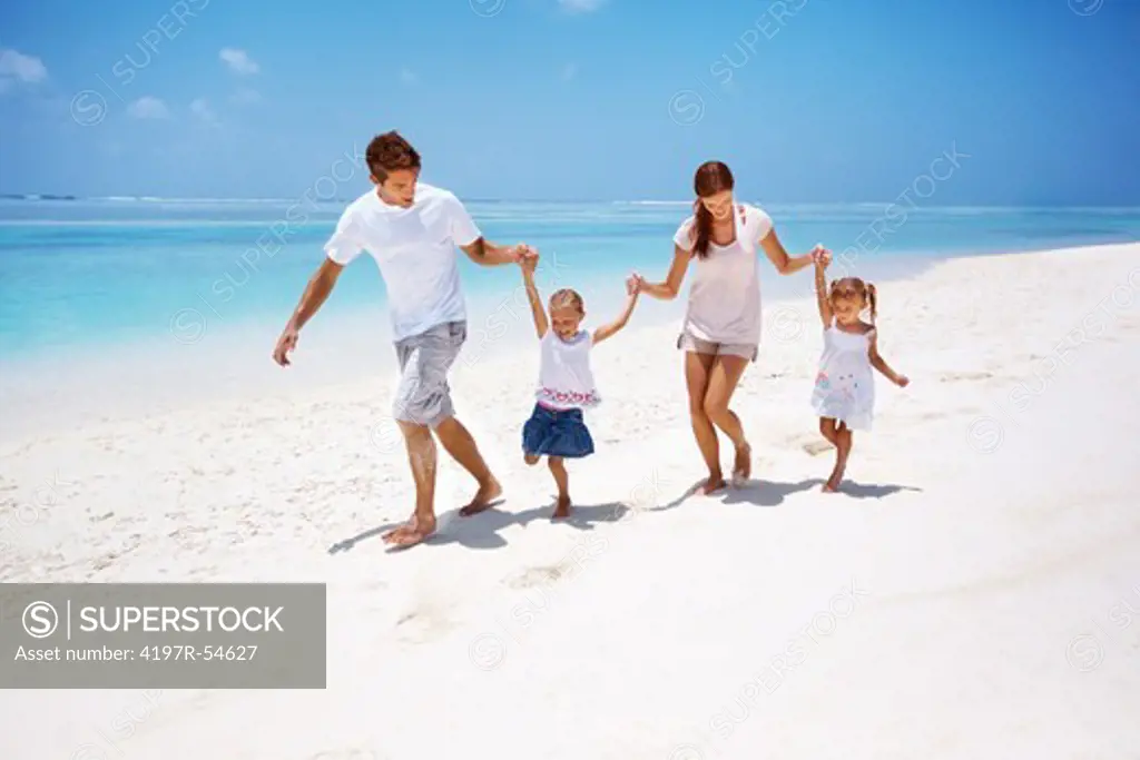 Playful young family together running at the seaside