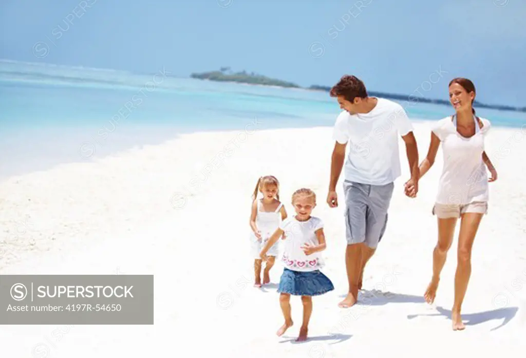 Cute young family running on the beach together