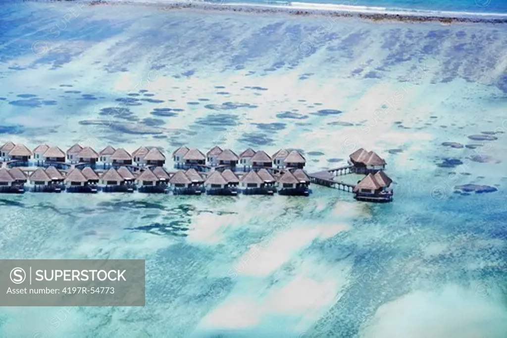 Aerial-view of a group of picturesque cabanas extending into a breathtaking blue sea