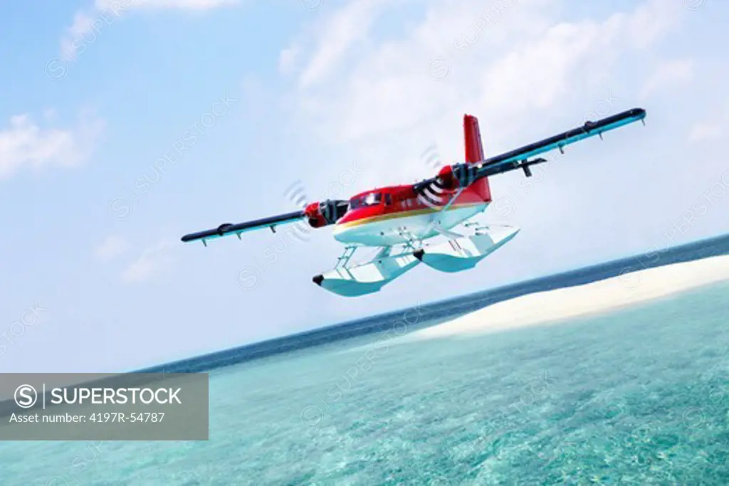 Seaplane takes to the skies above a crystalline sea and pearly white island