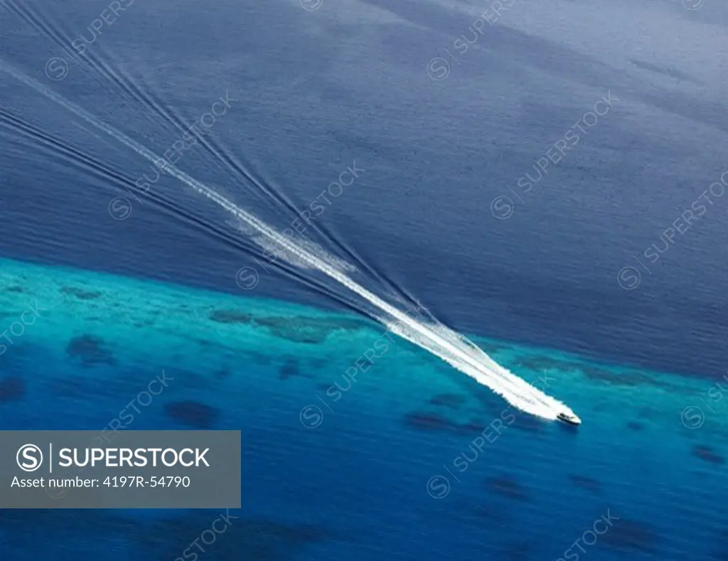 Birds eye view of a speed boat speeding along shallow and deep waters as it leaves its perfect wake behind