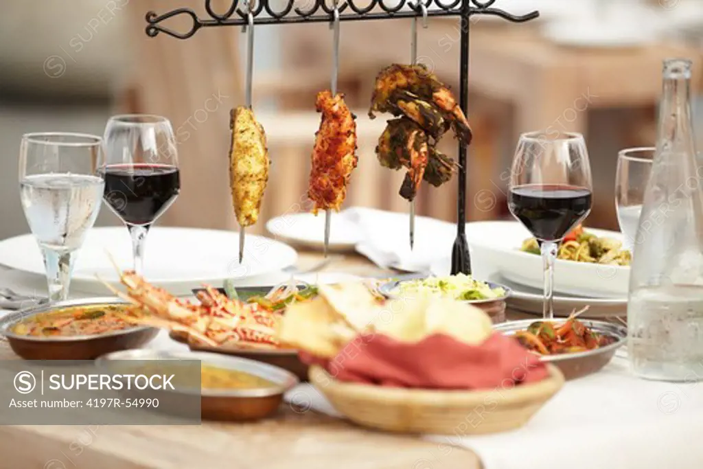A selection of meats sitting invitingly upon a dining table with an assortment of food dishes