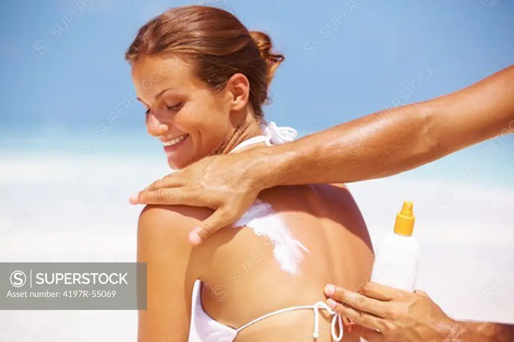 Portrait of man applying sunscreen lotion on gorgeous woman's back