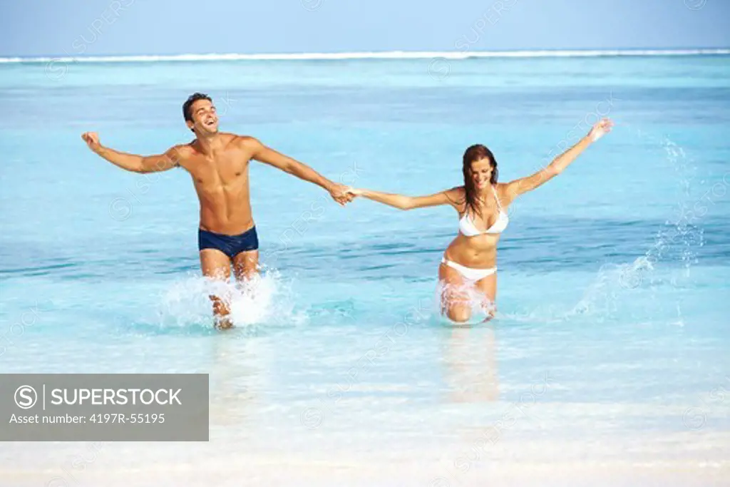 Portrait of happy young couple enjoying together on beach