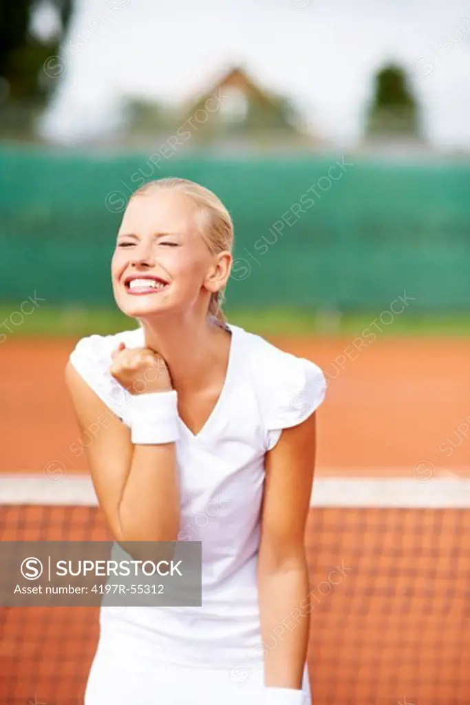 Beautiful young tennis player expressing victory and triumph on the court