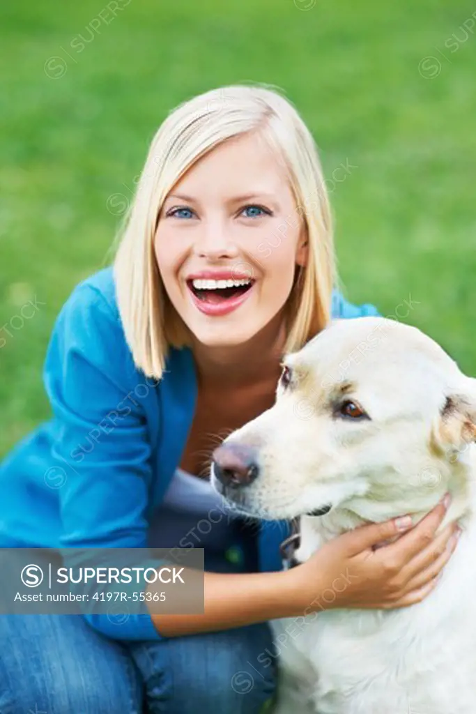 Laughing young woman hugging her labrador