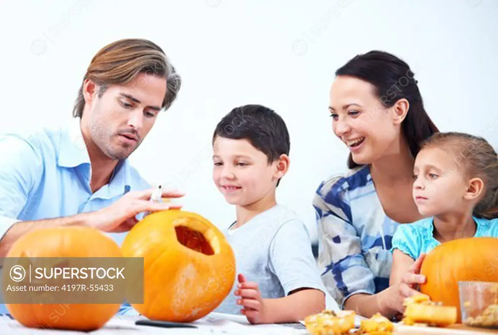 A young family making jack-o-lanterns for Halloween