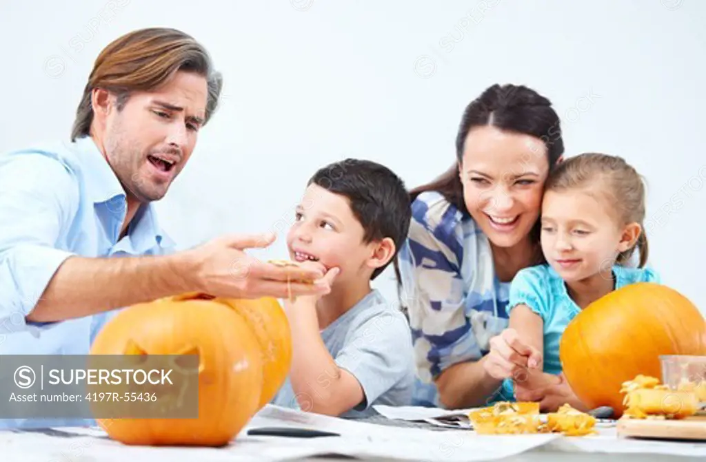 A young family making jack-o-lanterns for Halloween