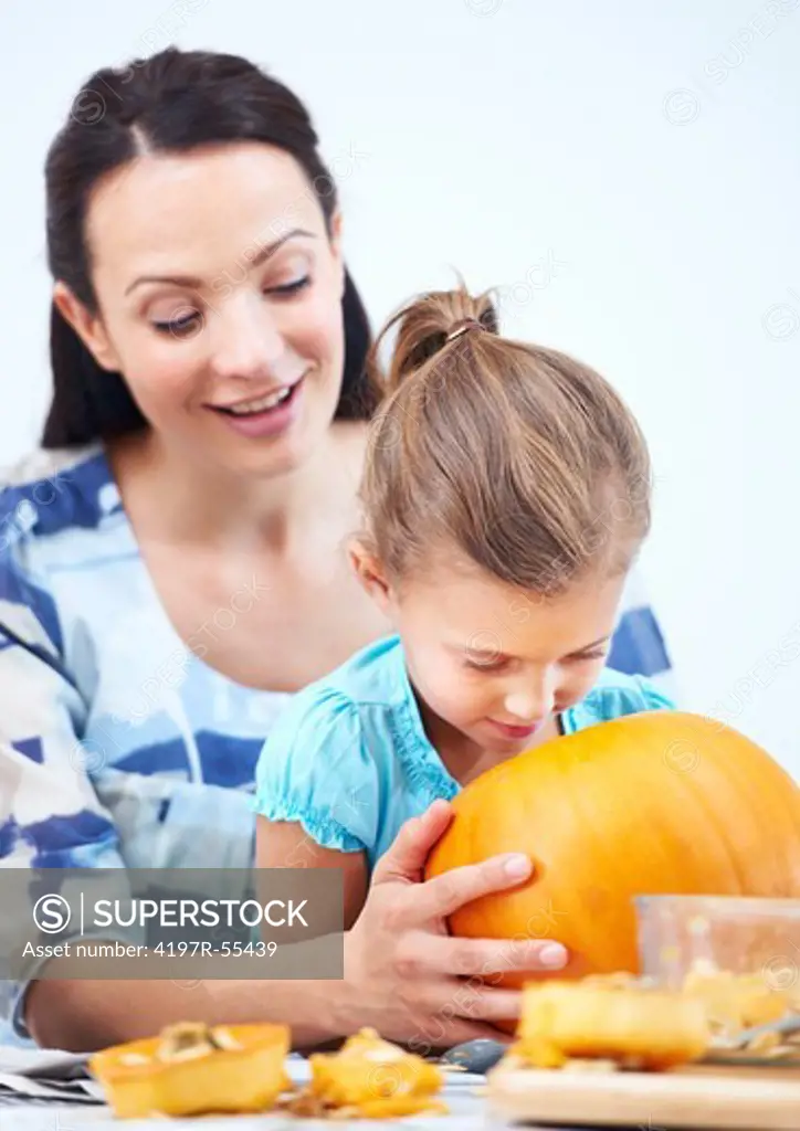 A little girl looking inside her halloween jack-o-lantern