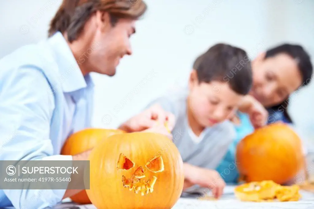 A young family carving Halloween decorations together
