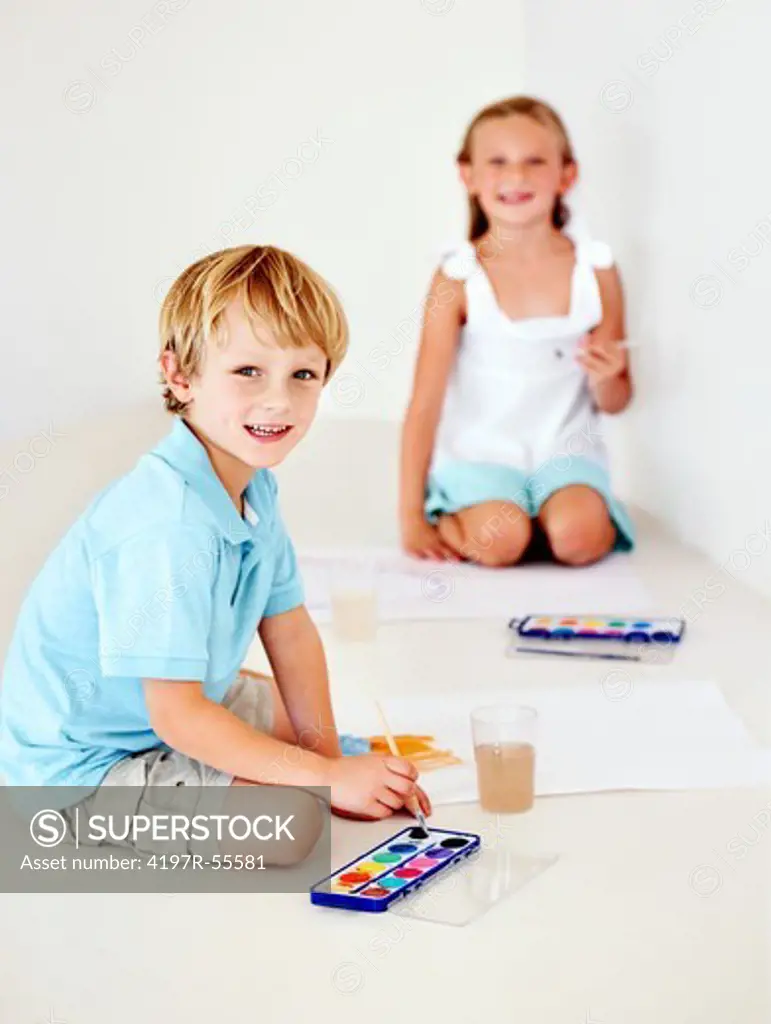 Adorable children painting some pictures using watercolours
