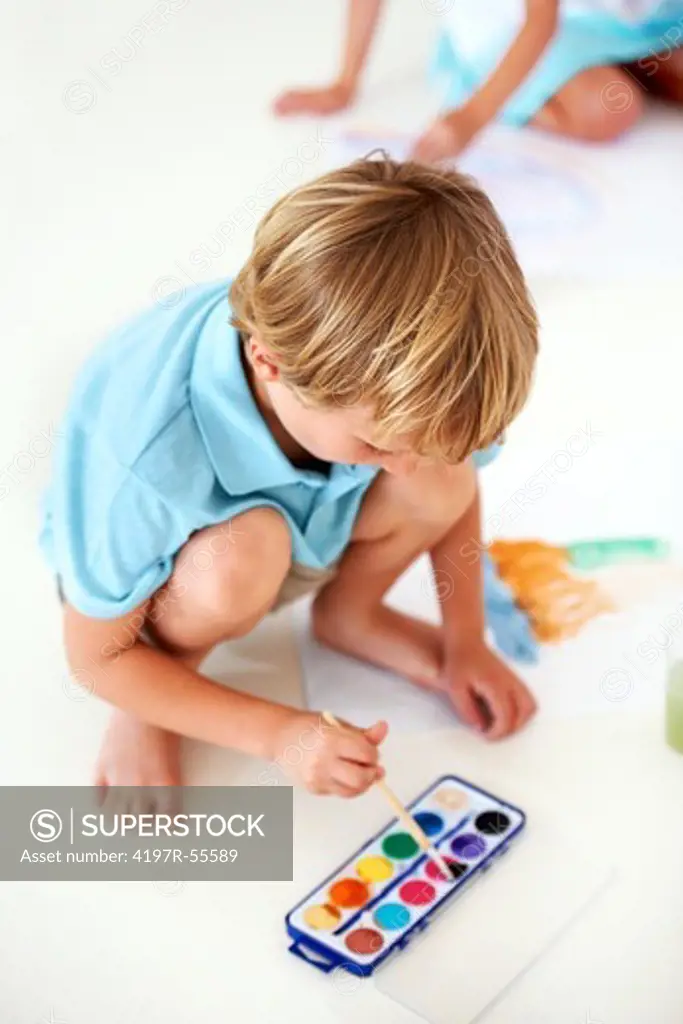 A high angle view of a young boy and his sister painting pictures with watercolours