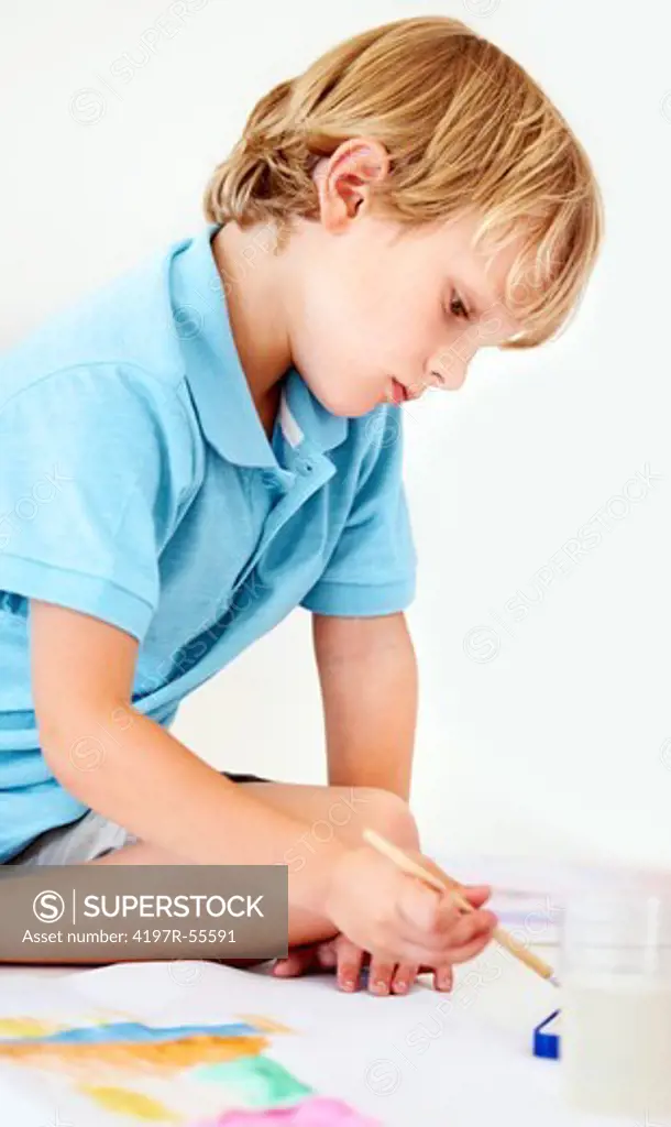 A young boy mixes watercolour paint for his picture