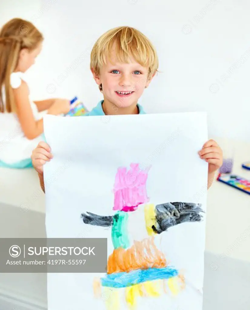 A young boy proudly displays his new watercolour painting for the camera