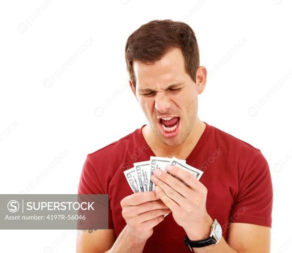 A young man yelling in excitement while he holds a wad of dollar bills