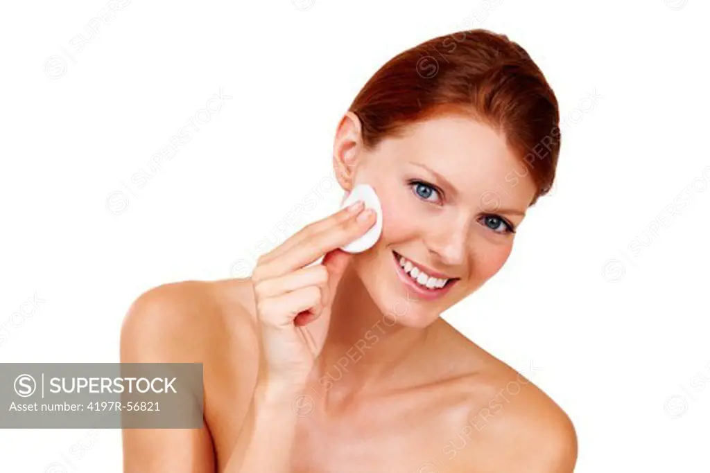 Portrait of a gorgeous young woman removing the makeup from her cheeks isolated on white