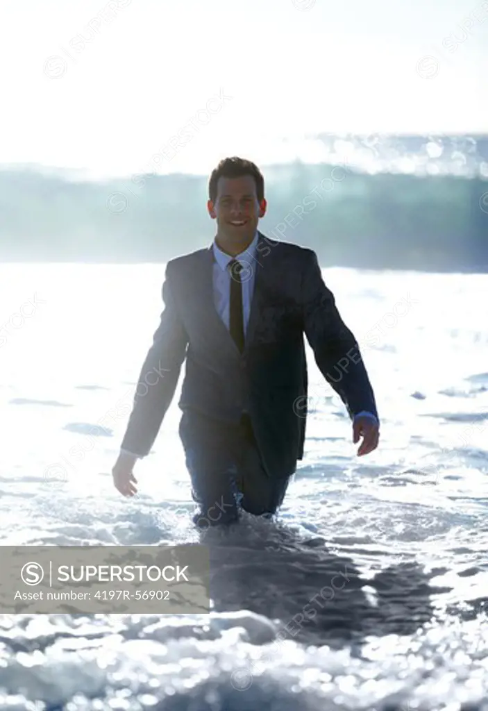 A business man walks through the rushing water toward the camera