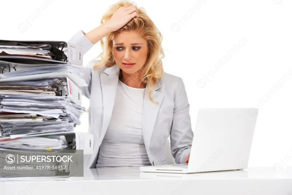 An overworked businesswoman looking anxiously at a pile of files next to her - Isolated