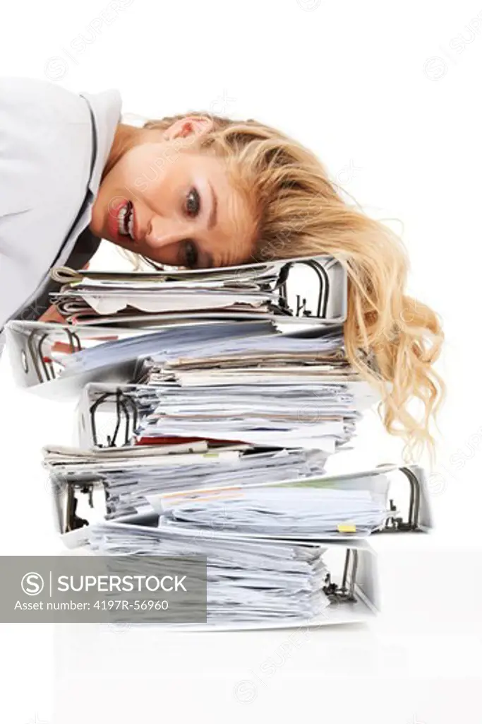 A frantic and overworked young woman lying on a pile of files - Isolated