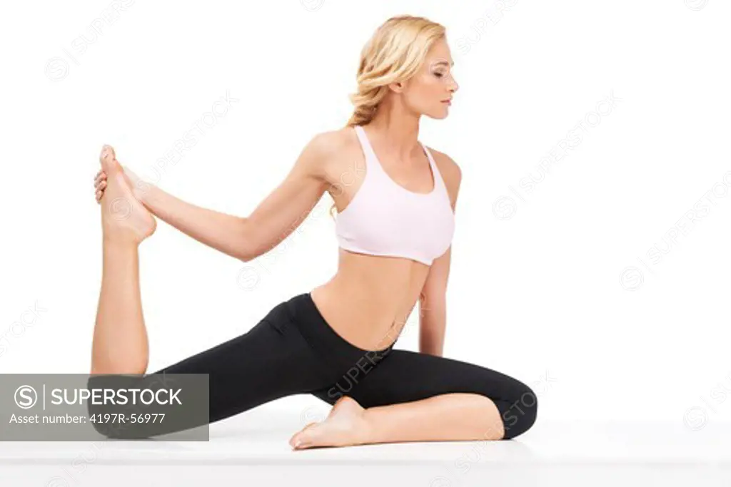A beautiful woman performing the sitting bow pulling pose while isolated on white