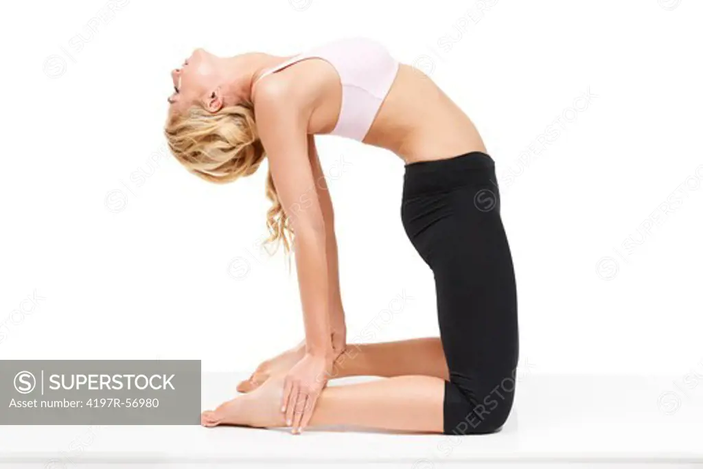 A beautiful woman performing the camel pose while isolated on a white background