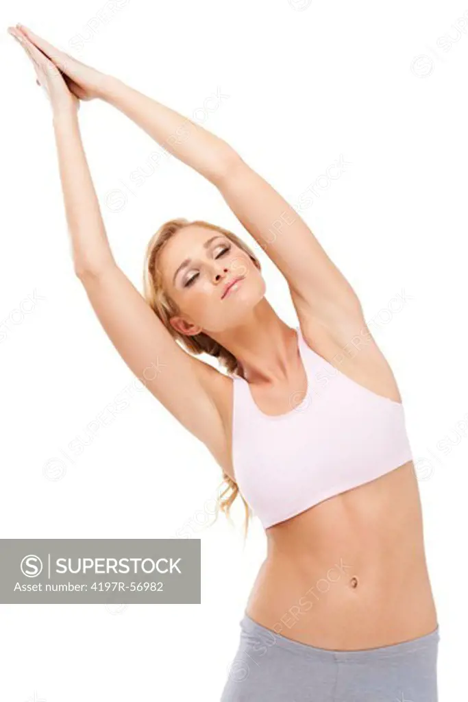 A beautiful young woman doing the half moon pose while isolated on white