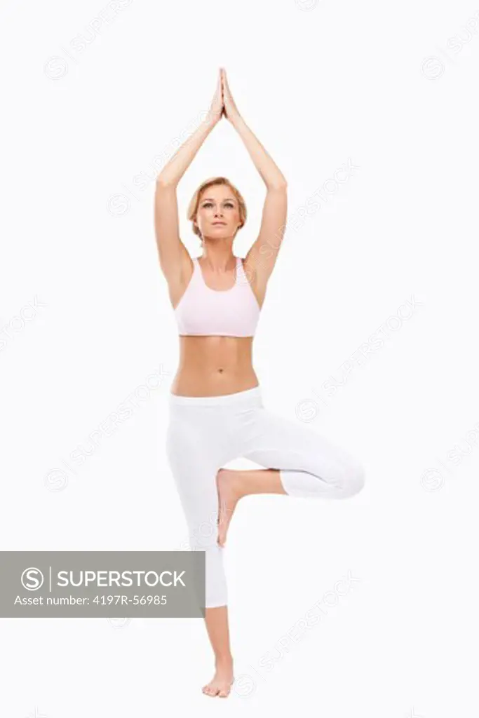 A young beauty performing the tree position while doing yoga - Isolated