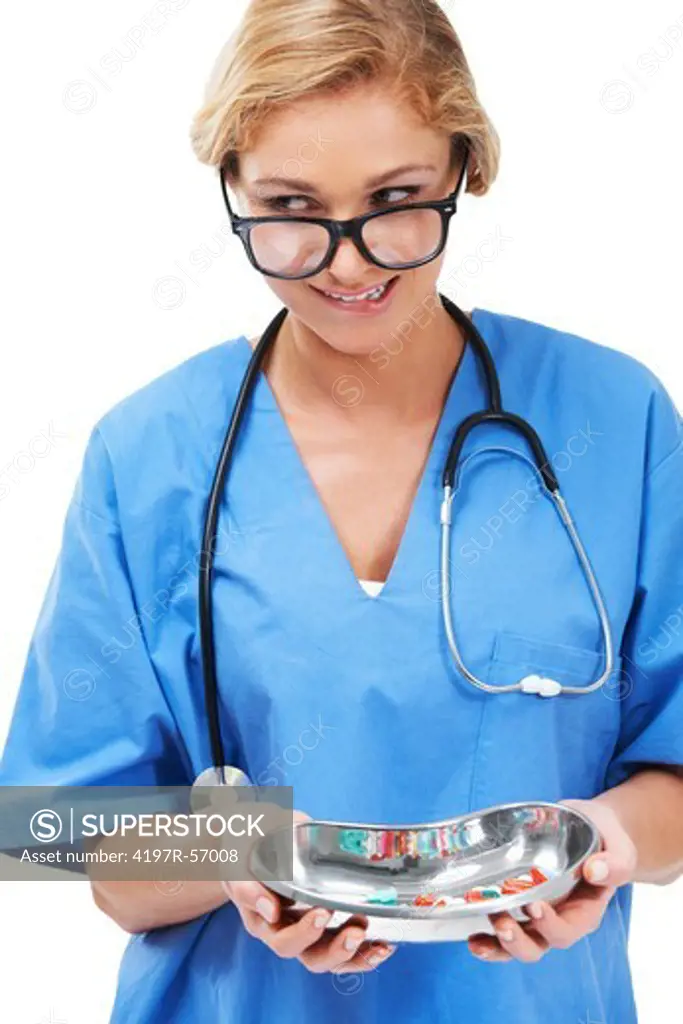 A pretty nurse wearing glasses holding a tray of medicinal capsules - Isolated