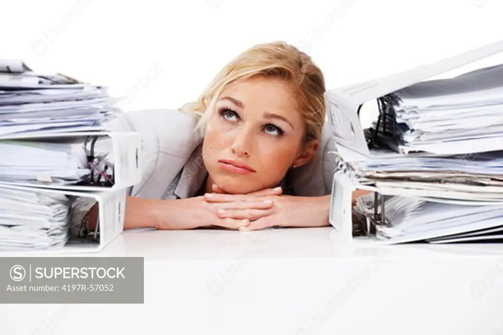 A pretty businesswoman looking towards the heavens pleadingly while hemmed in by stacks of files