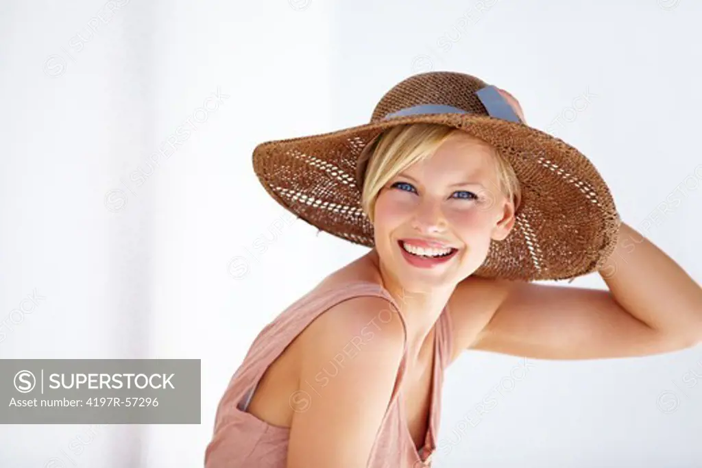 Portrait of an overjoyed young woman smiling happily and wearing a sunhat - Copyspace