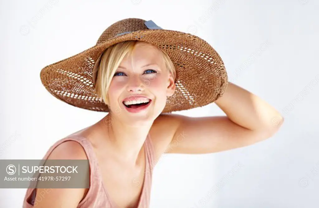 Portrait of a young woman laughing happily while wearing a sunhat