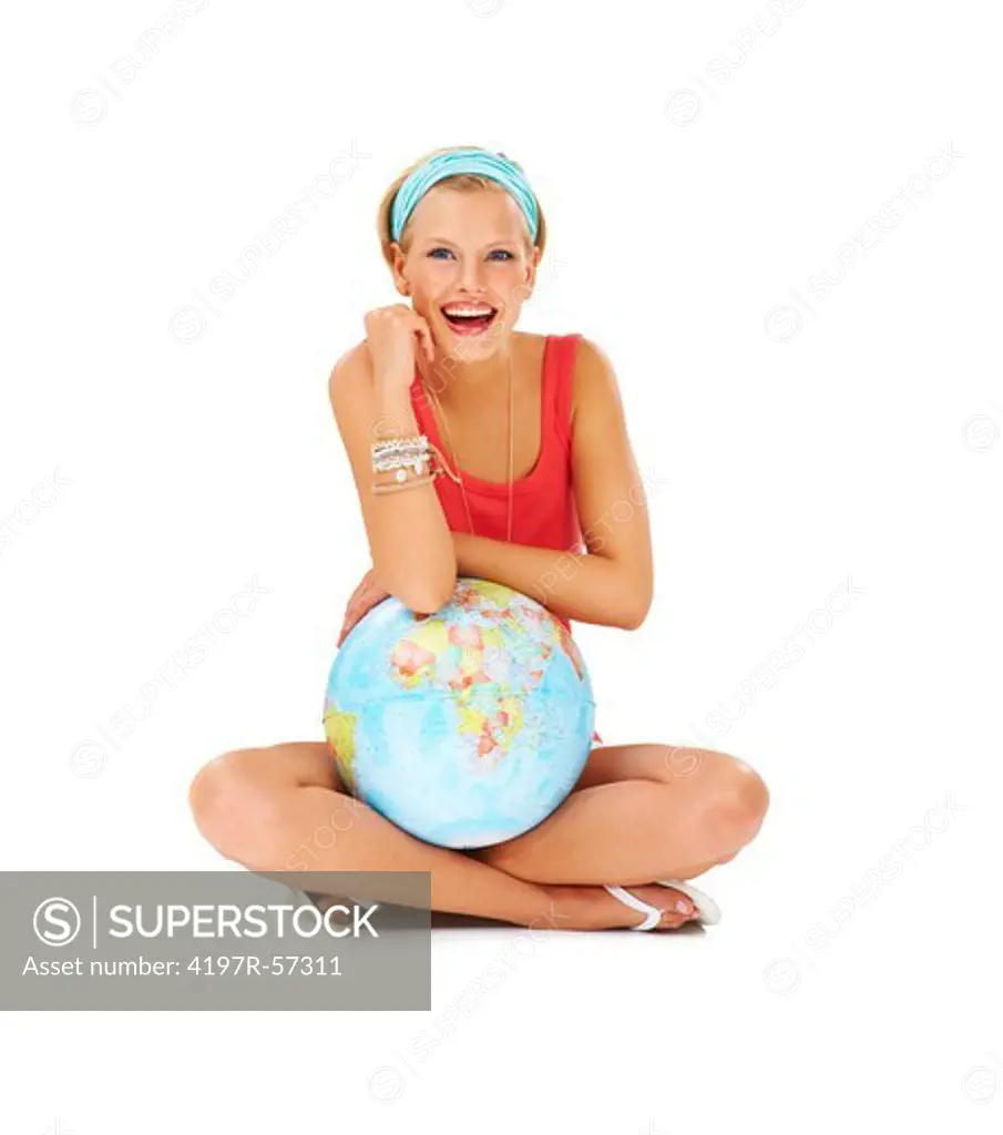 Laughing young woman sitting cross-legged and holding a globe of the world in her lap