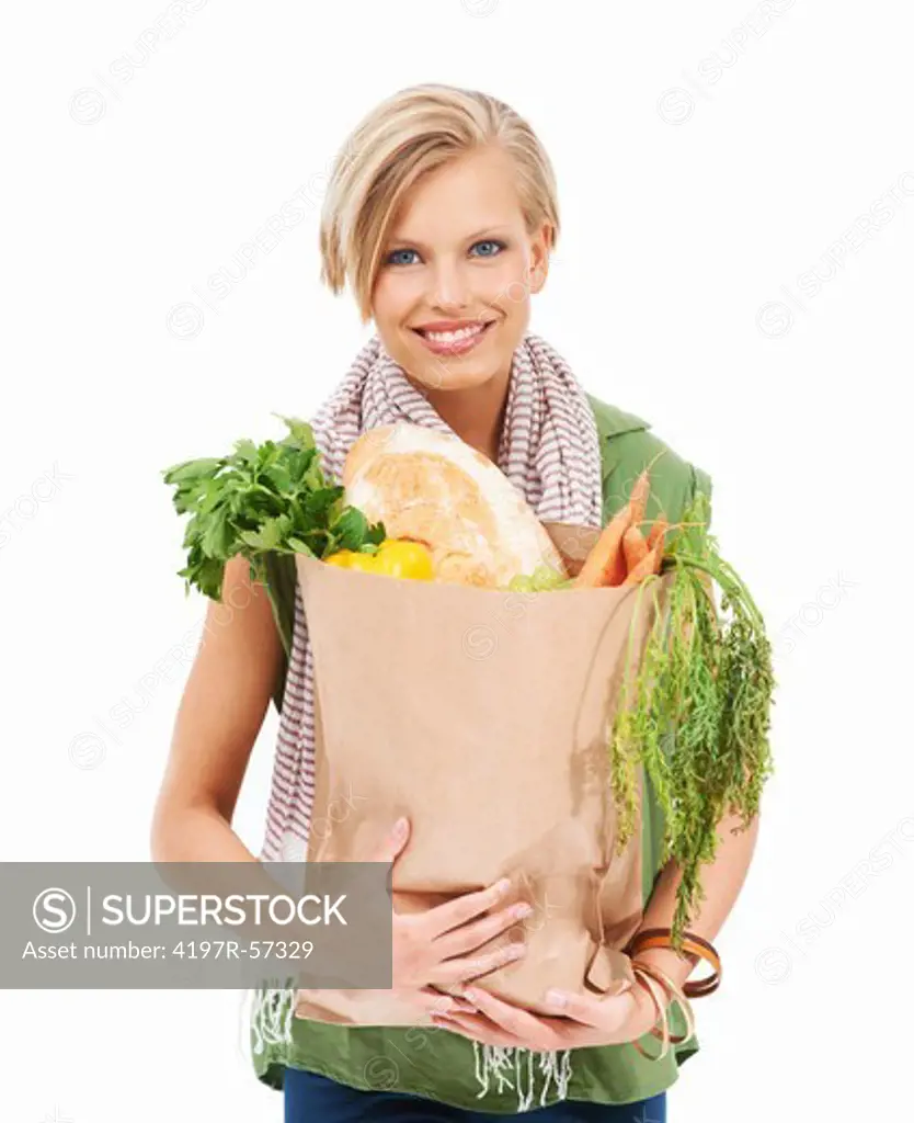 Happy young woman holding a paper bag of healthy groceries