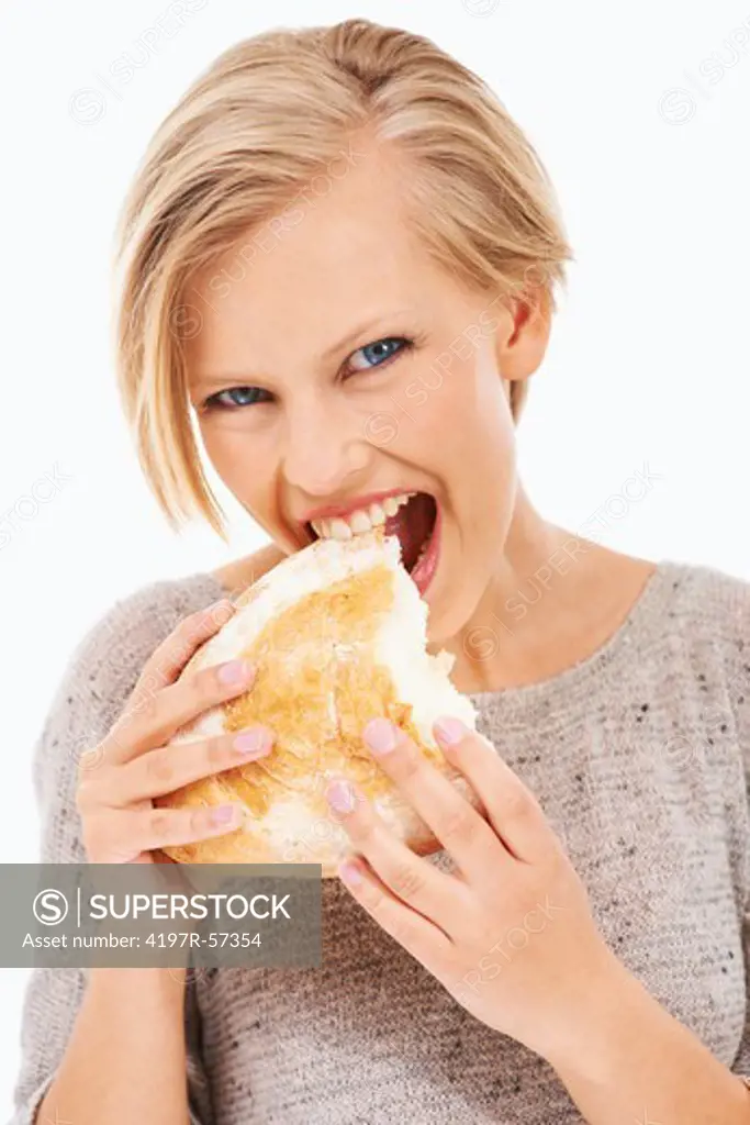 Pretty young woman biting into a piece of freshly baked bread