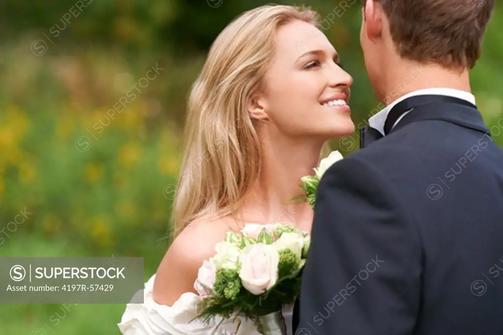 A beautiful young bride stares lovingly at her new husband