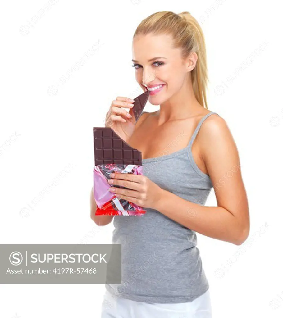 Happy young woman smiling while eating a slab of chocolate