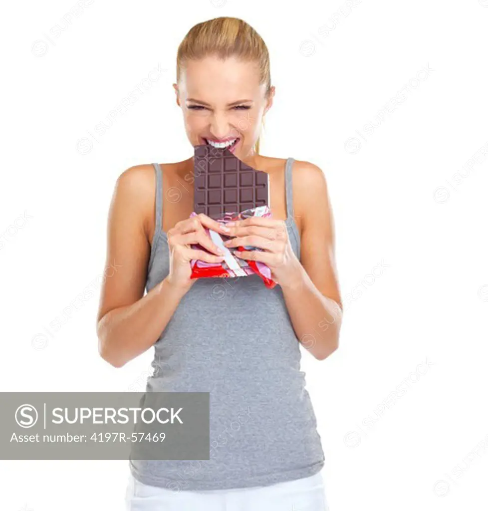 Expressive and gleeful young woman biting into a slab of chocolate