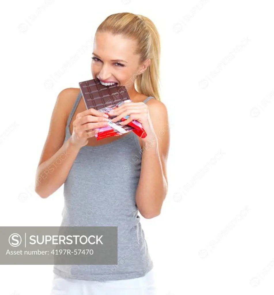 Eager young woman biting into a big slab of chocolate