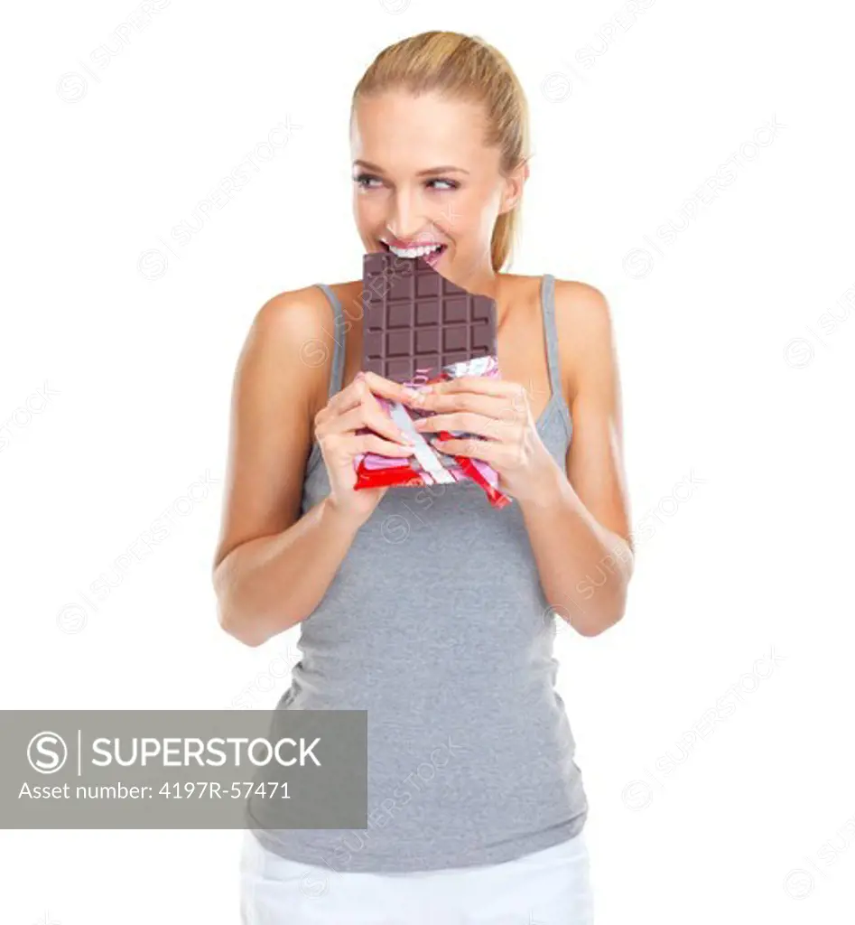 Gleeful young woman biting into a slab of chocolate