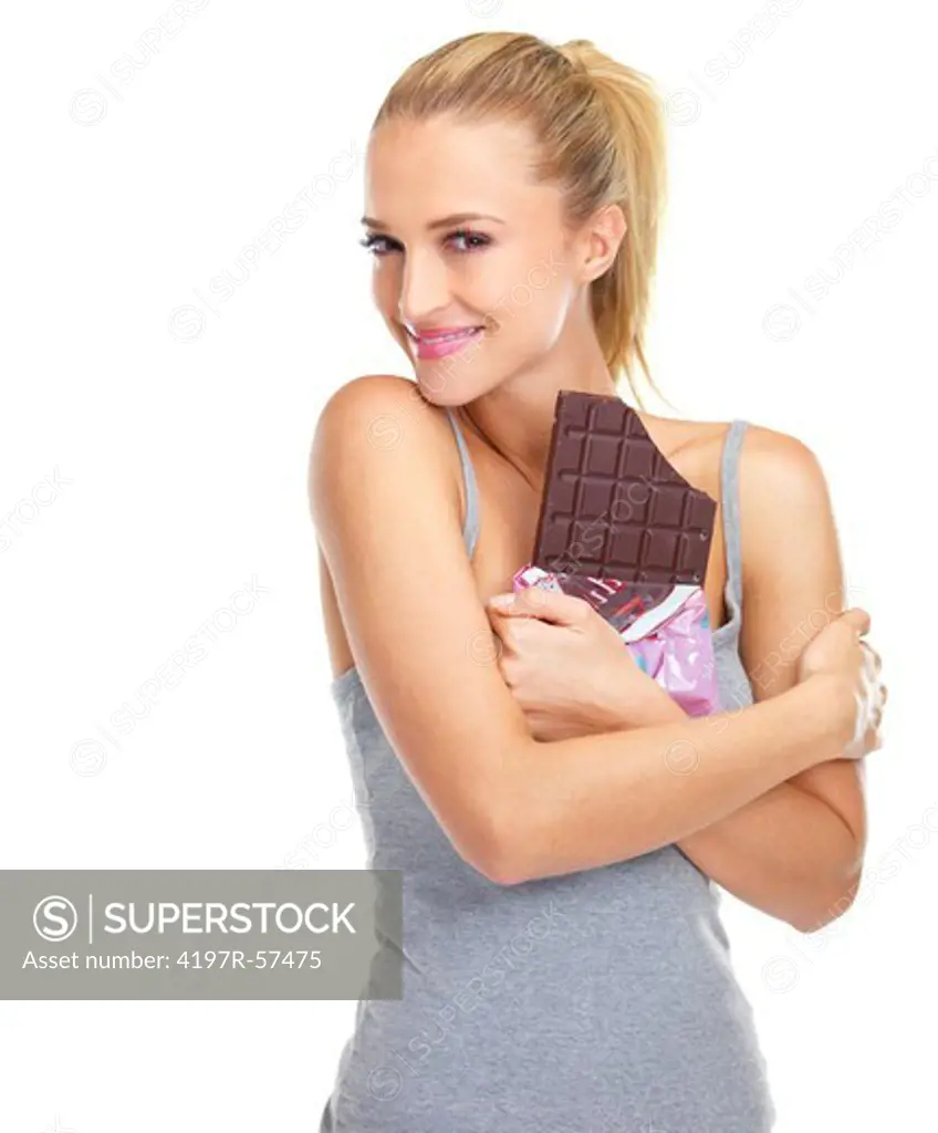Happy young woman holding a slab of chocolate close to her chest