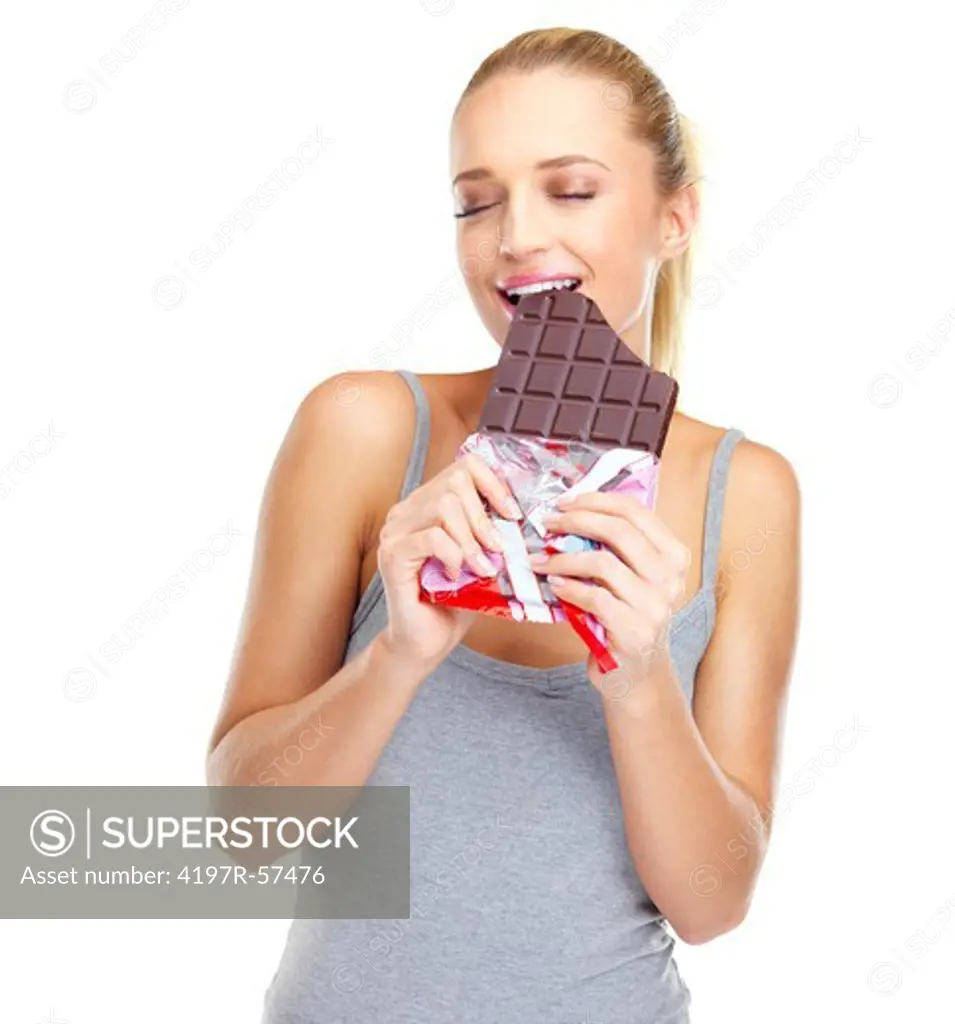 Relaxed young woman biting into a big slab of chocolate