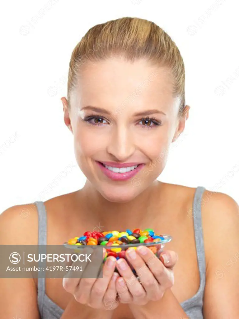 Smiling young woman looking away while holding a bowl of hard candy