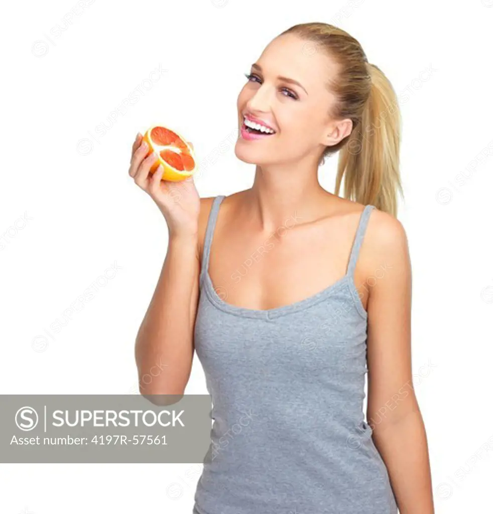 Laughing young woman holding half a grapefruit in her hand